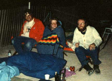 OASIS members Ed Hollowell, Diane Rhodes, and Dallas Legan attempt to keep warm while waiting for the shuttle to land.
