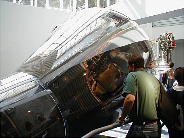 Photo of a visitor to the California Science Center examining a Gemini spacecraft.